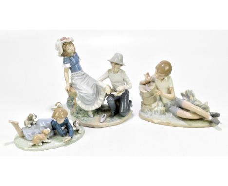 LLADRO; two figures comprising a boy playing with a bird, length 20cm, a girl playing with puppies, and a Nao figure of a boy