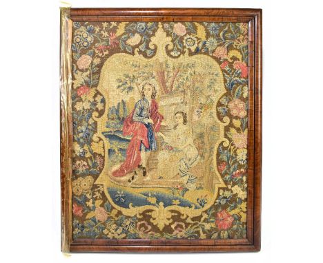 An 18th century wool work tapestry depicting young couple in Italianate landscape, within a floral decorated border and cushi