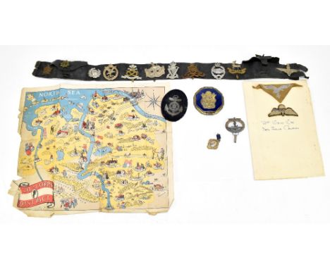 A small collection of British and German militaria, including a 30th Corps District map of the North Sea, assorted cap badges