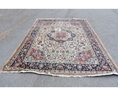 A Persian wool carpet, worked with a central medallion and allover floral design against an ivory coloured ground, 311 x 230c