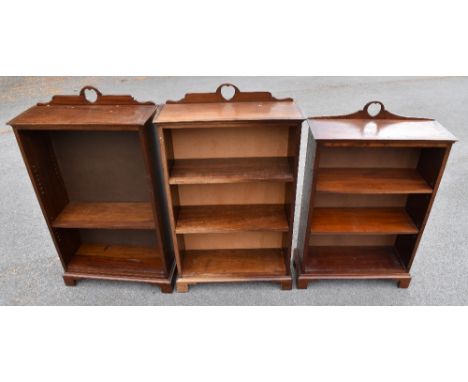 A pair of mahogany open fronted dwarf bookcases with an arrangement of two adjustable shelves on bracket feet and similar sma