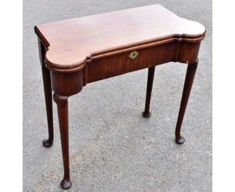 A George III mahogany fold over card table of shaped rectangular, on turned column supports, terminating on pad feet, width 7