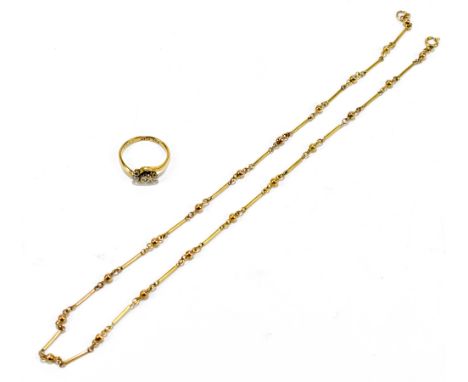 A 9ct yellow gold three stone dress ring, size K 1/2, and a yellow metal chain, length 40cm, combined approx. 6.4g (2).