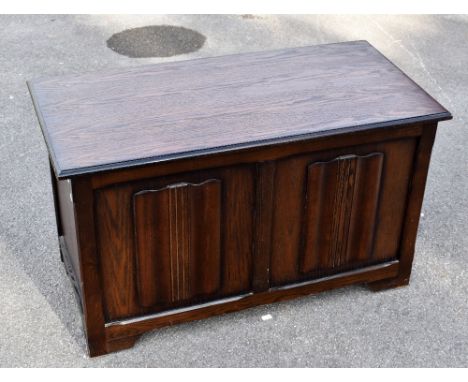 A reproduction oak effect blanket chest with linen fold detail to the front, on bracket feet, width 91cm, height 55cm, depth 