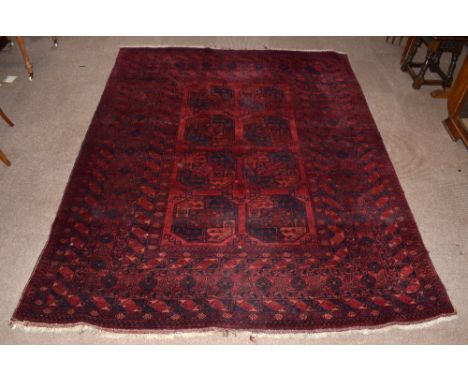 A Bokhara hand woven wool carpet, worked with eight geometric guls, 260 x 211cm.&nbsp;