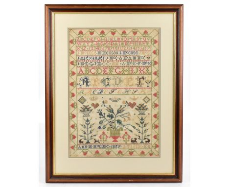 A Victorian needlework sampler, worked by Anne McCose and dated 1859, worked with alphabets and flowers, later framed and gla