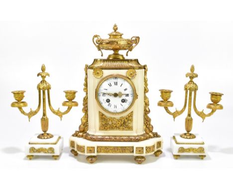 An early 20th century French gilt metal and alabaster three piece clock garniture, the clock with urn surmounts above applied