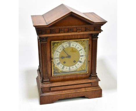A late 19th century German carved walnut eight day mantel clock of architectural form, with silvered Roman numeral chapter ri