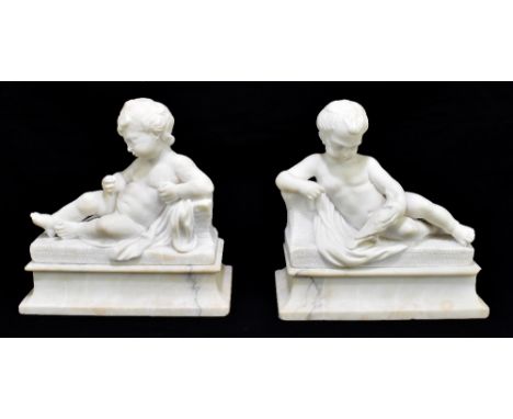A pair of carved alabaster cherubic figures, one holding a dove and both set on stepped rectangular bases, length 22.5cm.Addi