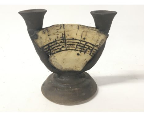 A Contemporary ceramic double candle stick the centre section with simulated music by Bernard Rooke height 15cm