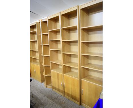 SUITE OF LIGHT OAK FINISH SHELVING COMPRISING THREE NARROW SHELVES WITH CUPBOARD BASES, ONE WIDE SHELF WITH DOUBLE CUPBOARD B