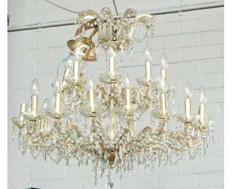 A gilt-metal and glass twenty-four light chandelier20th CenturyWith scroll branches hung with faceted cut-glass drops, 94cm h