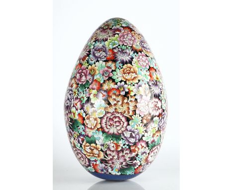A large cloisonné eggdecorated with a profusion of flowers against a black ground, 53cm highLarge shallow dent to lower half 