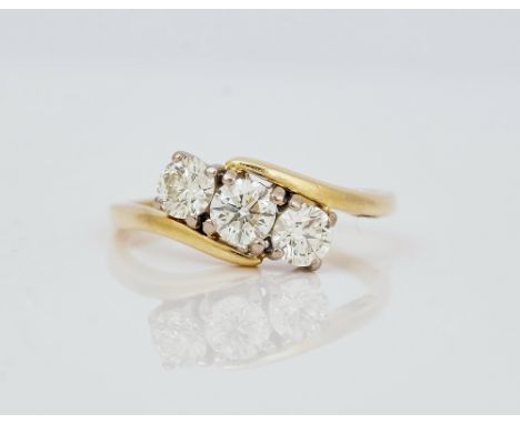 An 18ct gold and diamond set three stone ringClaw set with a row of circular cut diamonds in a crossover design, detailed 1.0