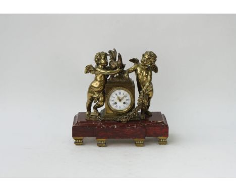 A French gilt-metal and rouge marble mantel clockLate 19th centurymodelled as two cherubs and a cockerel, 3.5in white enamel 