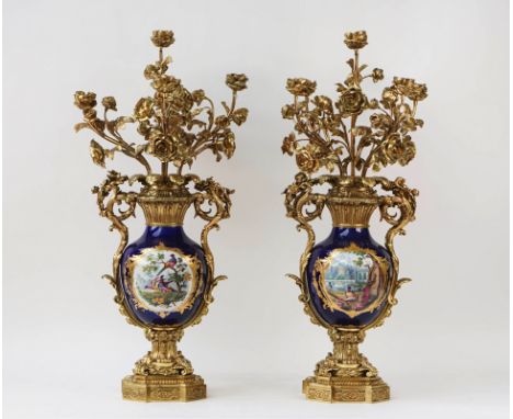A pair of French gilt-metal and porcelain five light candelabra20th CenturyThe branches modelled as roses, above a porcelain 