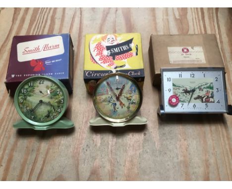 Three vintage 1950s Smiths clocks to include ‘Circus’ alarm clock, cowboy and country side scene, all boxed and apparently un