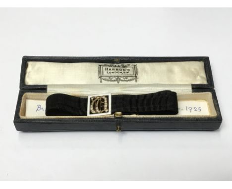 1920s black silk bracelet with 9ct gold enamel and seed pearl panel with gothic initial with engraved gold clasp, in original