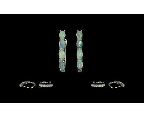 Opal J-Hoop Earrings, four oval cut opals, displaying a variety of colours, set down the front of each J-hoop, which is hinge