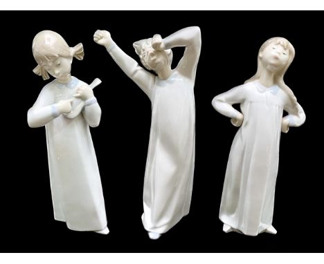 Three Lladro Figures, comprising 9" girl Lladro girl in nightdress, hands on hips, 9" girl in nightdress with lute, and a 9" 