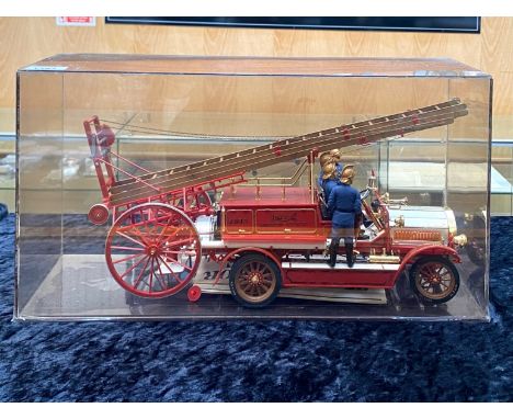 A Diecast Model of a 1914 Dennis Fire Engine, housed in a perspex box, depicting the engine with four fire fighters in unifor