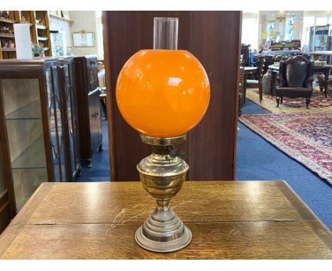 Brass Oil Lamp with orange glass shade and interior chimney.  In good condition.