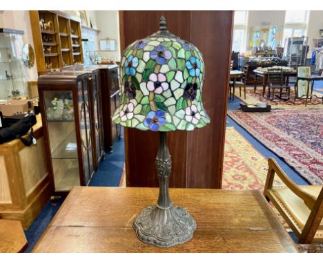 Tiffany Style Lamp, with bell shaped shade in colours of green blue and pink, raised on a metal base decorated with designs o