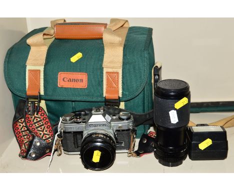 A CAMERA BAG CONTAINING A CANON AE-1 FILM SLR, fitted with a FD 50mm f1.8 lens, a Canon 177A Speedlite, a Super Paragon 80-20