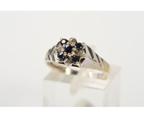 A 9CT WHITE GOLD SAPPHIRE AND DIAMOND CLUSTER RING, designed as a central, raised circular sapphire, within a circular sapphi