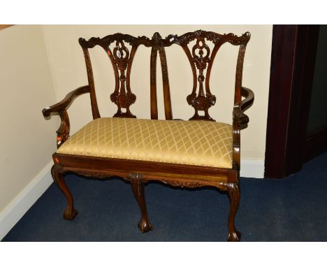 A REPRODUCTION MAHOGANY CHIPPENDALE STYLE TWO SEATER SOFA, with gold upholstered drop in seat pad on ball and claw feet, widt