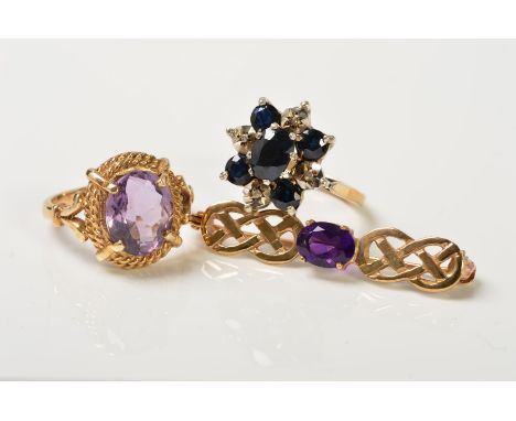 TWO RINGS AND A BROOCH, the first ring designed as an oval amethyst in a four claw setting within a double rope twist surroun