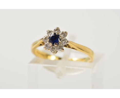 AN 18CT GOLD SAPPHIRE AND DIAMOND CLUSTER RING, the central circular sapphire within a brilliant cut diamond surround, with 1