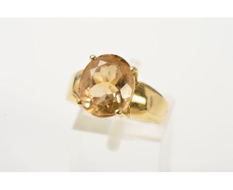 A 9CT GOLD CITRINE RING, designed as an oval citrine within a four claw setting, to the tapered band, with 9ct import mark fo