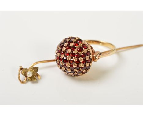 A 9CT GOLD GARNET DRESS RING AND A STICKPIN, the ring designed as a domed panel set with circular garnets interspaced by smal