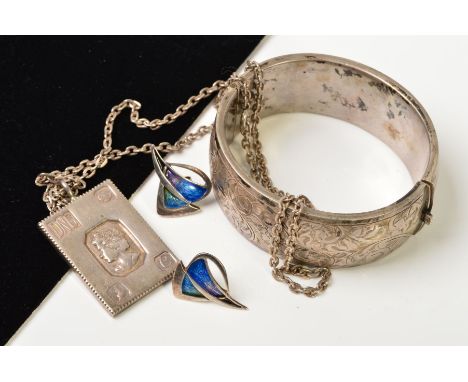 THREE ITEMS OF SILVER AND WHITE METAL JEWELLERY, to include a silver hinged bangle with engraved scrolling floral and foliate