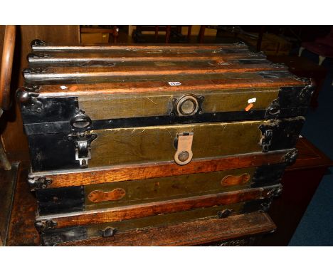A VINTAGE WOODEN AND METAL BANDED TRAVELLING TRUNK, bearing various travel labels, width 82cm x depth 46cm x height 53cm (s.d