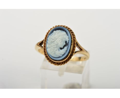 A 9CT GOLD CAMEO RING, the oval glass cameo depicting a lady in profile within a rope twist surround to the bifurcated should