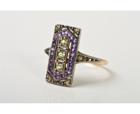 AN AMETHYST AND PERIDOT DRESS RING, the rectangular panel set with a vertical row of three peridots, within an elongated hexa