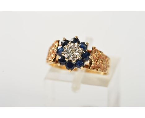 A 9CT GOLD SAPPHIRE AND DIAMOND CLUSTER RING, the central single cut diamond within an illusion setting, to the claw set, cir