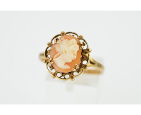 A 9CT GOLD CAMEO RING, the central oval cameo panel depicting a lady in profile, within a scrolling and beaded surround to th