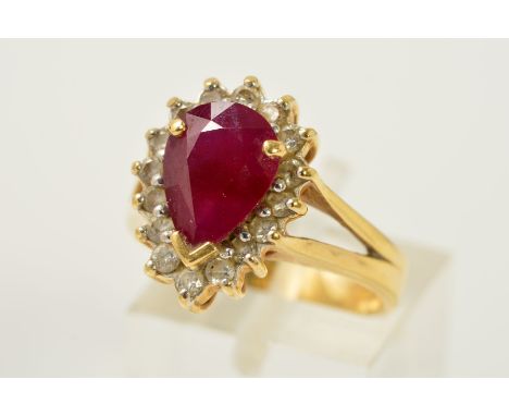 AN 18CT GOLD GLASS FILLED RUBY AND DIAMOND CLUSTER RING, designed as a pear shape glass filled ruby within a brilliant cut di