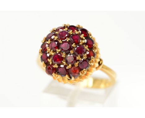 A GARNET AND RED PASTE DRESS RING, designed as circular garnets and red paste in a circular, slightly domed cluster to the te