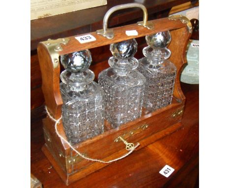 Edwardian oak & brass Tantalus with three decanters