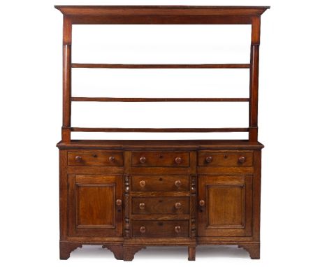 A VICTORIAN OAK AND MAHOGANY WELSH DRESSER with a plate rack above six drawers and two cupboards, all with turned knobs and r