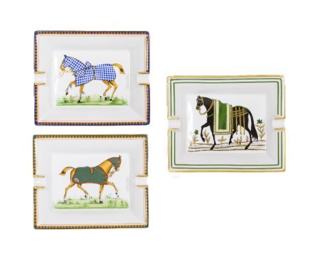 THREE HERMES PORCELAIN ASHTRAYS each decorated with horses, 19.5cm x 16cm Condition: the blue glazed ashtray with a chip to t