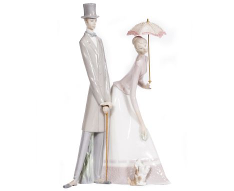 A LARGE LLADRO PORCELAIN FIGURINE Couple with parasol, first issued in 1969 and sculpted by Fulgencio Garcia, 30cm wide at th