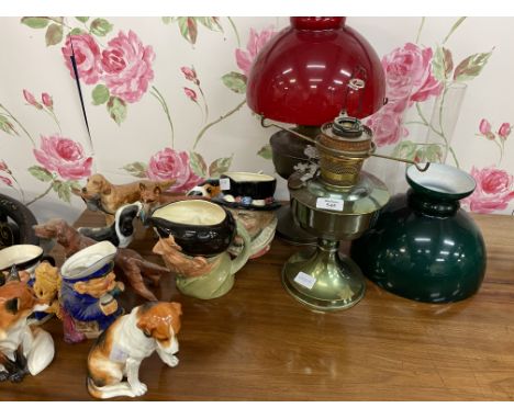 TWO OIL LAMPS one with a red glass shade, one with a green glass shade; two Royal Doulton character jugs; a Beswick porcelain