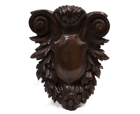 A CARVED HARDWOOD WALL BRACKET with central shield and scrolling surround, 33cm wide x 42cm high Condition: minor marks, dent