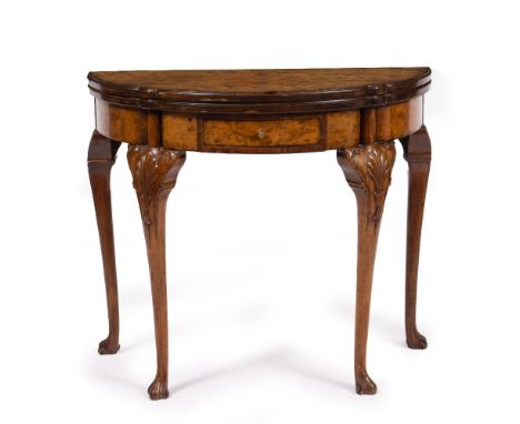 AN EARLY 20TH CENTURY WALNUT DEMI LUNE FOLD OVER CARD TABLE with a green baize top, turned cabriole legs and scroll feet, 84c