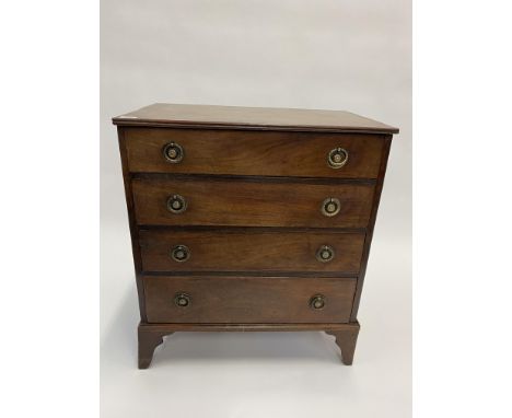 A 19TH CENTURY MAHOGANY CHEST OF FOUR LONG DRAWERS with brass ring handles and bracket feet, converted from a commode, 65.5cm